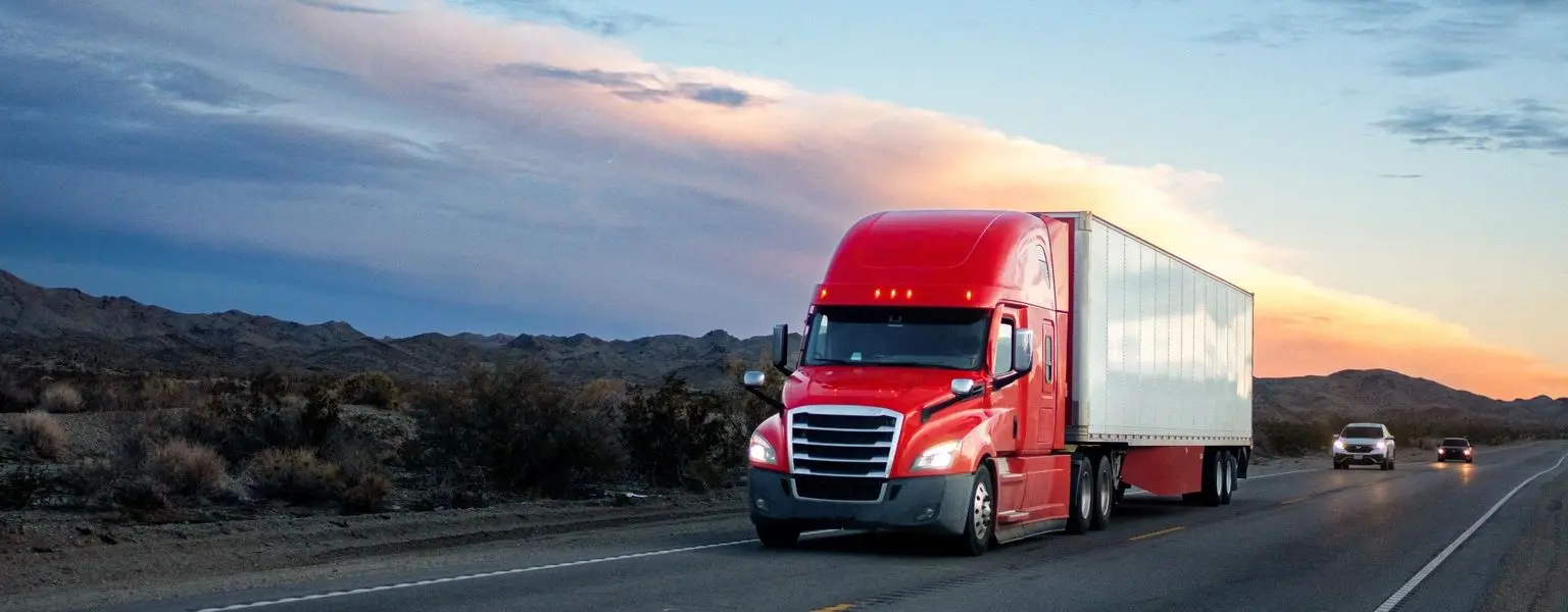 Long haul truck on open highway at sunset